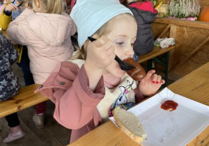 dzieci jedzą pieczone kiełbaski