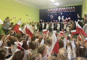 dzieci unoszą flagi podczas występu