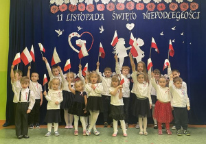 dzieci pozują unosząc w dłoni Flagę Polski