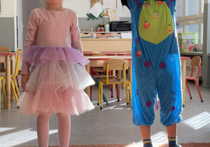 Chłopiec w stroju potwora i dziewczynka w stroju księżniczki pozujący do zdjęcia