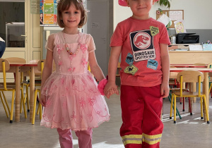 Dziewczynka w stroju księżniczki i chłopiec w stroju strażaka