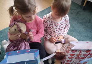 Dziewczynki oglądają wygrane w loterii fantowej prezenty
