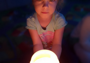 Sala przedszkolna. Dziewczynka trzyma świecę.