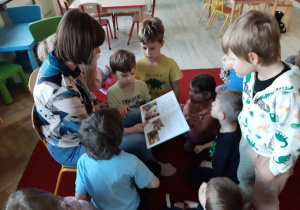 Dzieci z uwagą słuchają czytanej książki