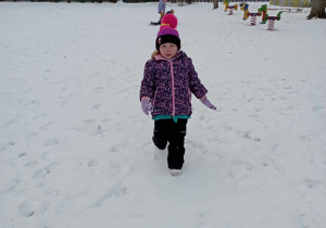 Dziewczynka biegnie po śniegu