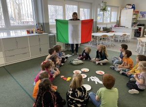 dzieci siedzą na dywanie i poznają kulturę Włoch