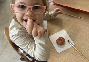Dziewczynka pokazuje posypkę do pączków w kształcie serca