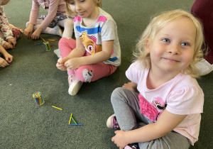 dzieci układają litery A z kolorowych patyczków