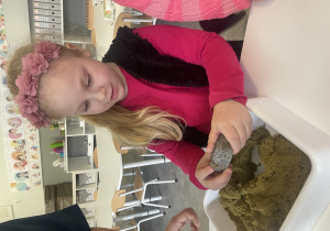 dzieci bawią się w paleontologów i oczyszczają skamieliny
