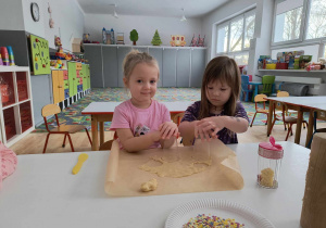 Sala przedszkolna. Dzieci nadają kształt ciasteczkom.