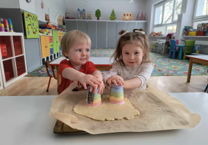 Sala przedszkolna. Dzieci nadają kształt ciasteczkom.