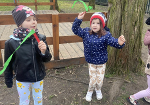 Dzieci na ogródku machający zielonymi szarfami podczas powitania wiosny