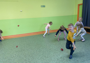 Dzieci na sali gimnastycznej podczas zabawy w rzucanie się kulkami z papieru