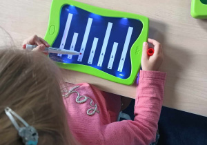 Dziewczynka prowadzi po śladzie na świecącej tabliczce